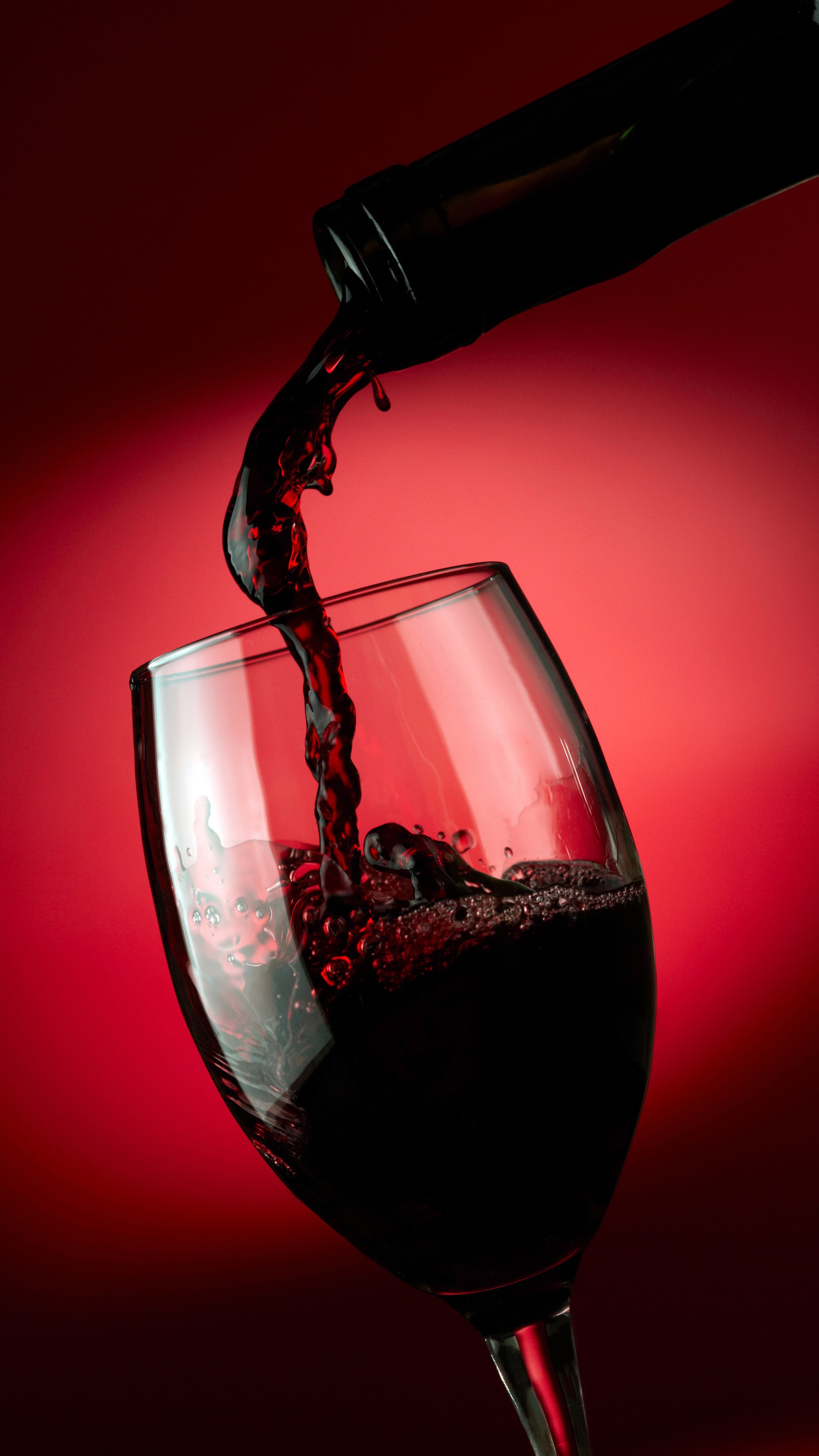 A glass of red wine being poured