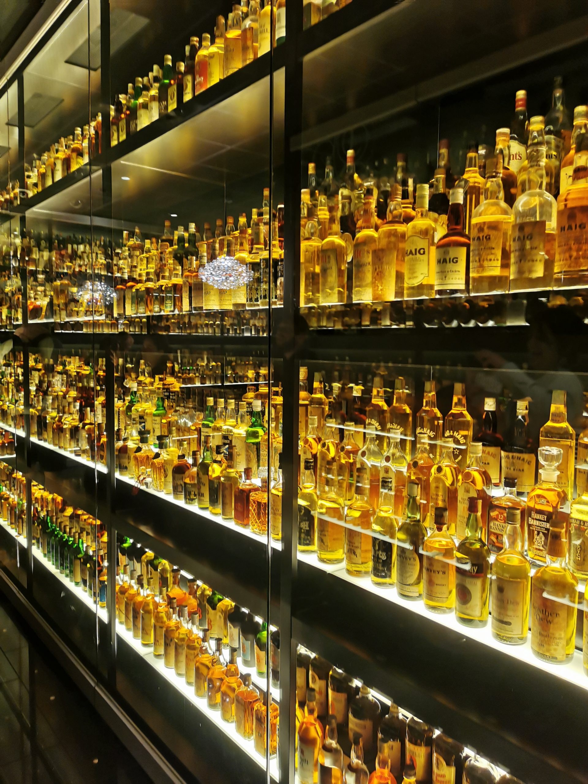 Backlit whiskey bottles glowing amber
